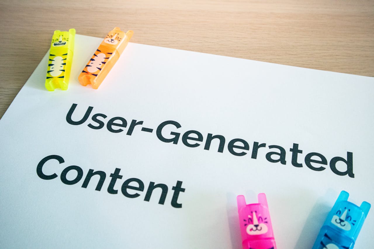 Bright highlighters on a User-Generated Content note against a wooden desk.